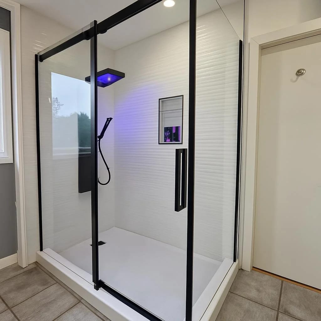 Modern bathroom renovation with a black-framed glass walk-in shower and tile feature wall